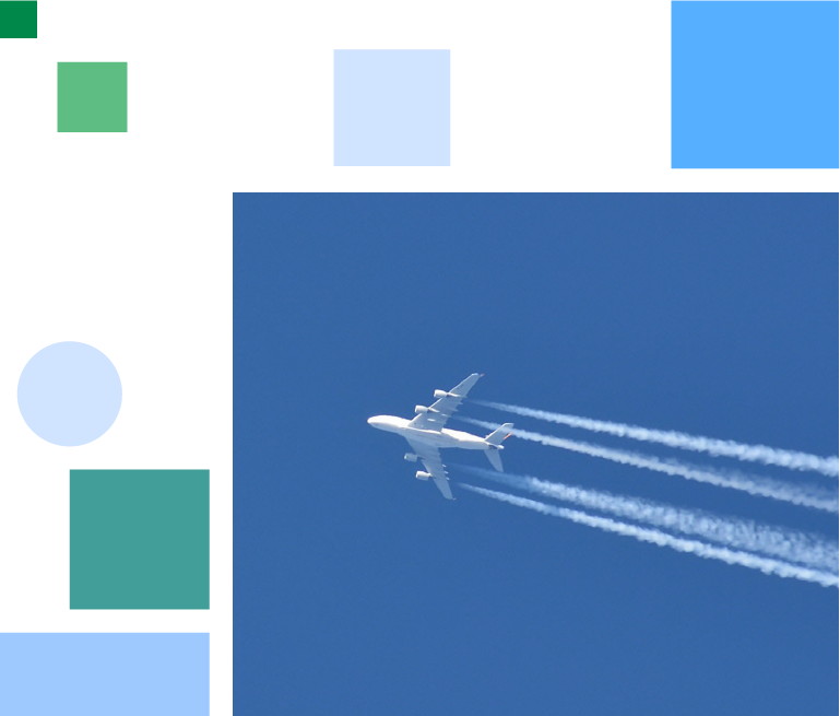White airplane with condense stripes from below in front of a blue sky 
