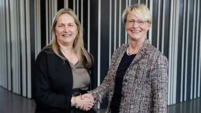 Siobhán Duffy, CEO of Element Six and Katrin Kobe, CEO of BOsch Quantumg Sensing, shaking hands, looking into the camera.